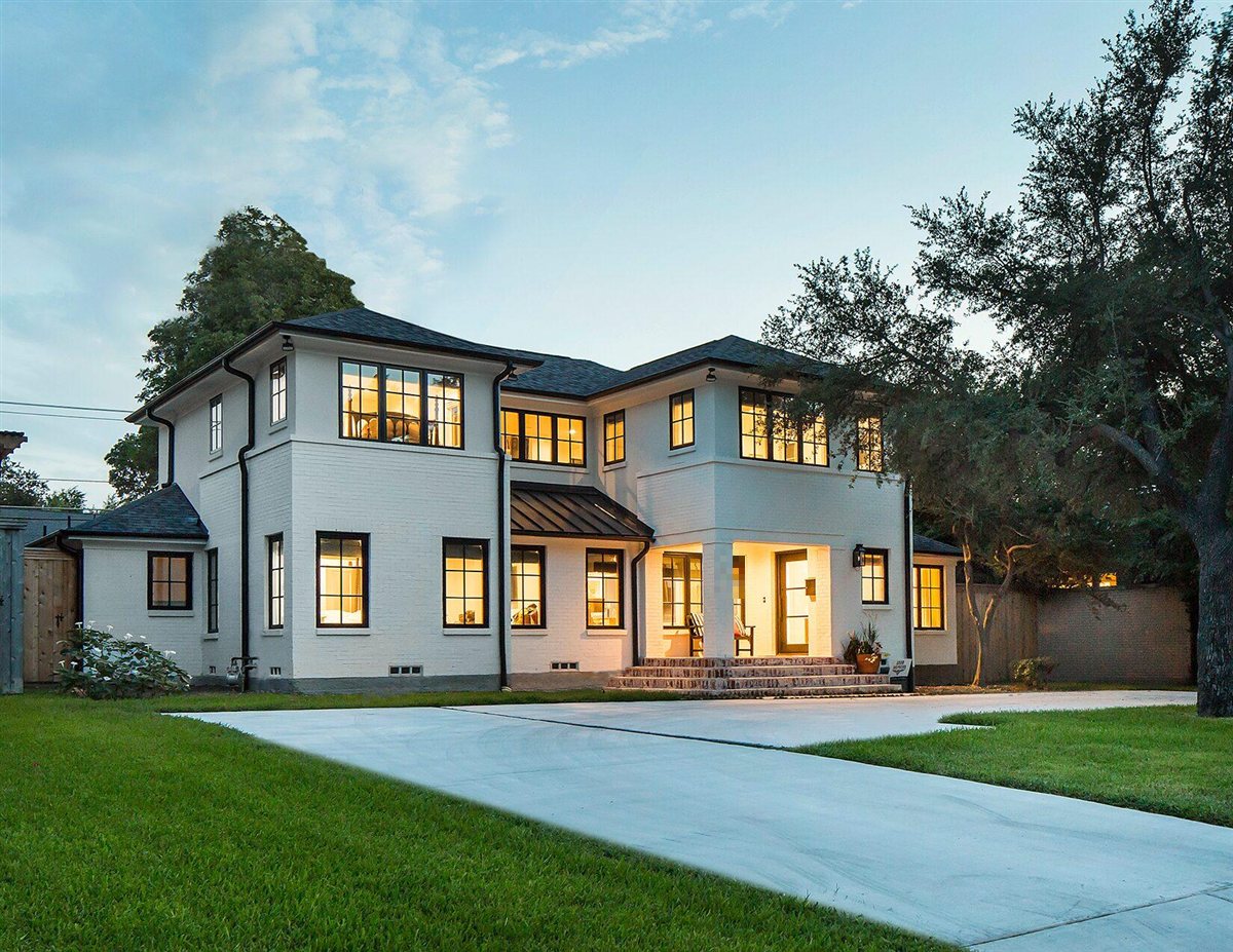 Renovated two-story white brick home at dusk